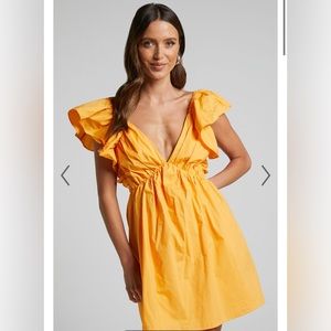 Showpo Raiza Mini Dress- Ruffle Sleeve Tie Back Plunge Dress in Marigold